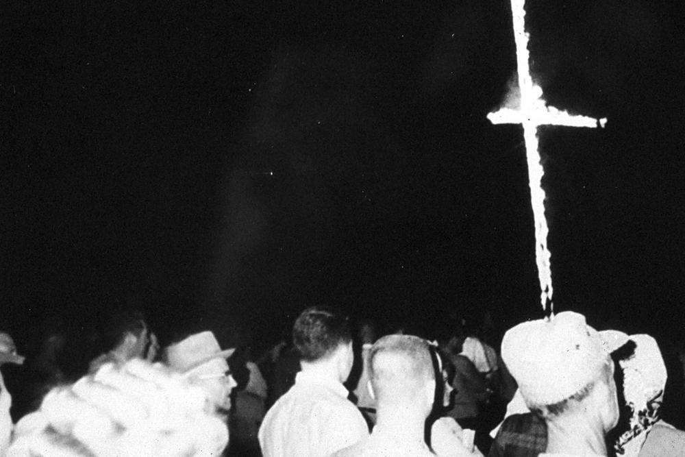 Crowd of people at a Ku Klux Klan cross burning.