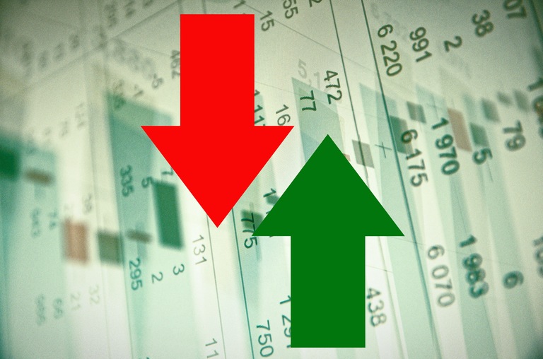 Stock image depicting stock prices with a red arrow pointing down and a green arrow pointing up in foreground.